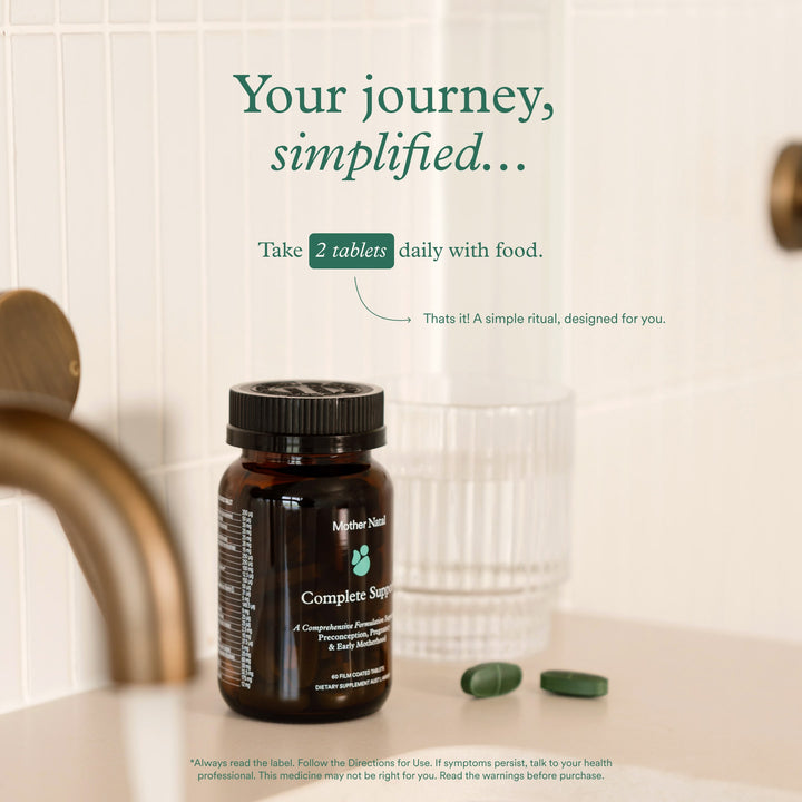 Mother Natal prenatal bottle on a bathroom counter with a glass, text advising taking two tablets daily with food.